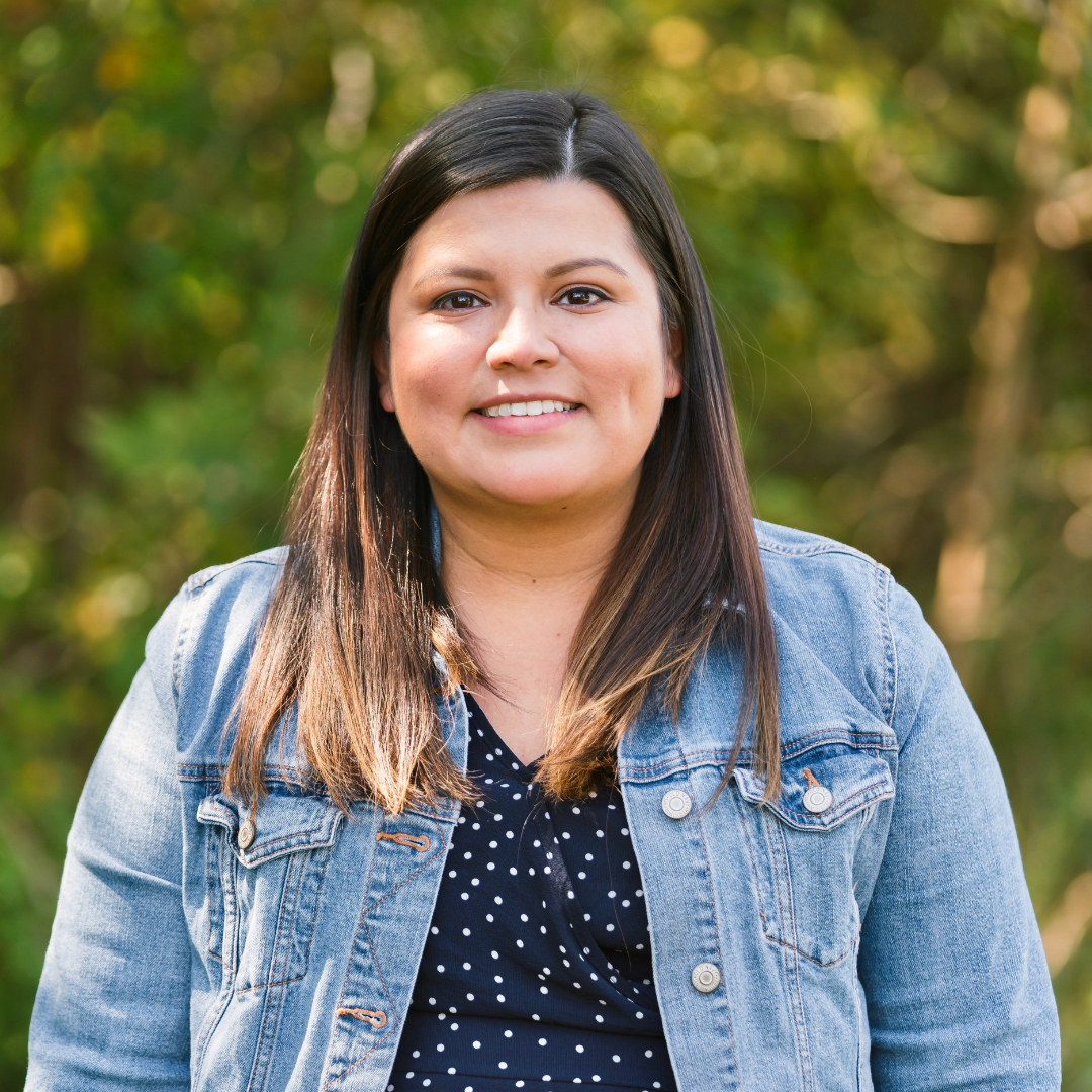 Itzel smiling with tree greenery in the background